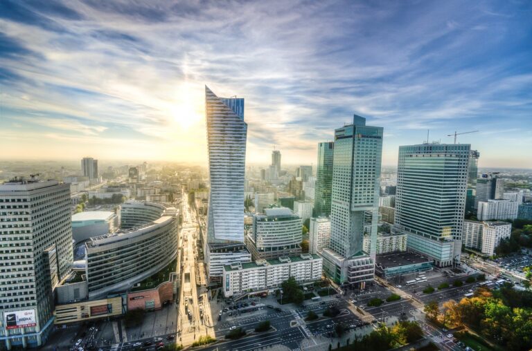 Centrum Warszawy o poranku. Widoczne wieżowce, w tym Złota 44 i InterContinental. Jasne, lekko zachmurzone niebo